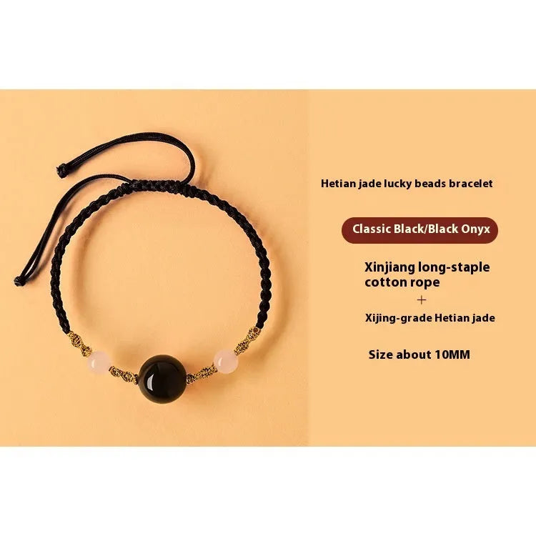Hand-woven red rope bracelet with Hetian jade beads and a detailed zodiac charm pendant.