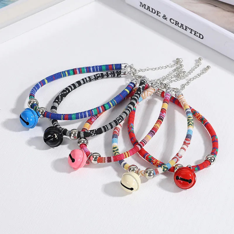 Coloured ethnic pattern adjustable pet collar with metal bell and D-ring on a nylon strap.
