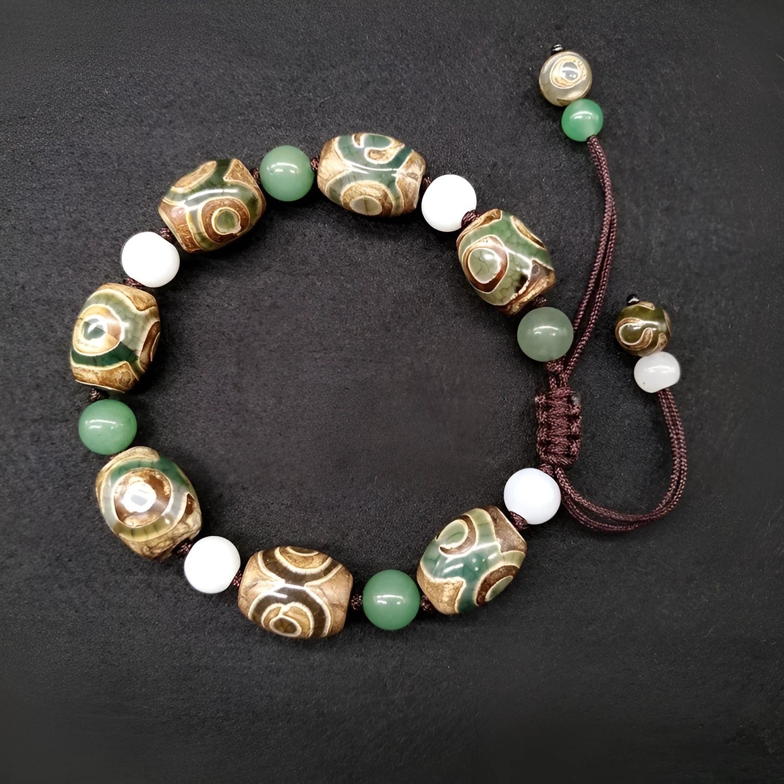 Green agate Tibetan bracelet with three-eye geometric bead pattern and adjustable cord closure