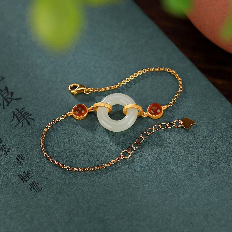Gold-coloured women's bracelet with a silver and jade peace buckle on an adjustable chain.