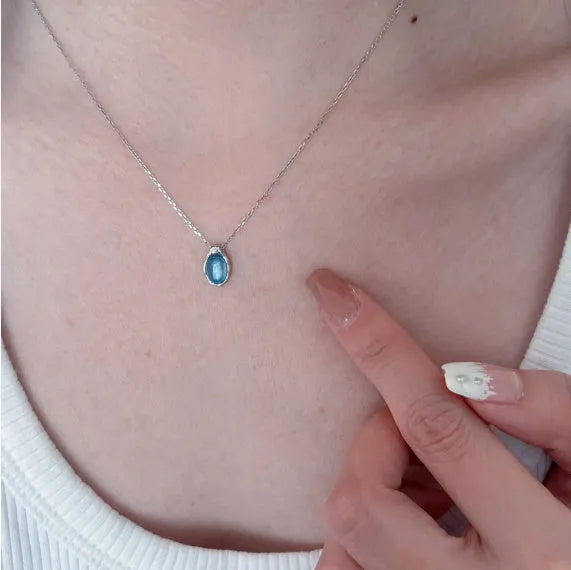 Geometric navy blue water drop pendant necklace on an adjustable copper chain.