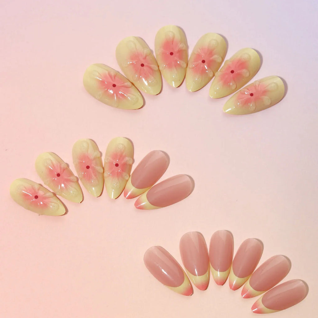 Set of plastic fake nails with raised cartoon flower designs, jelly glue, and a nail file on a pink background.