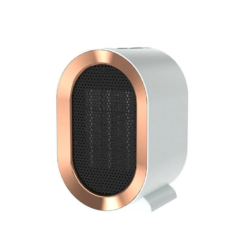 A compact black desktop electric fan heater with mechanical control dials, shown on a wooden desk.
