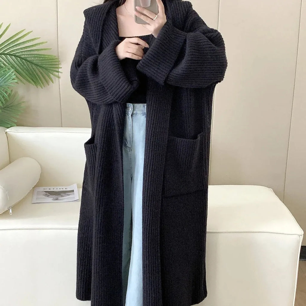 Loose grey hooded cardigan coat for women with long sleeves on a hanger.