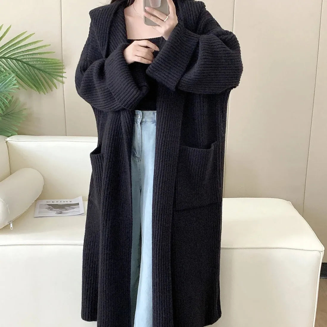 Loose grey hooded cardigan coat for women with long sleeves on a hanger.