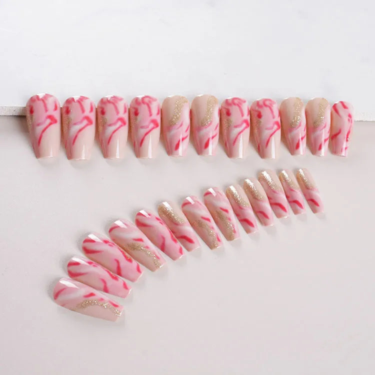 Set of pink press-on artificial nails with rose pattern, shown next to a bottle of nail glue.