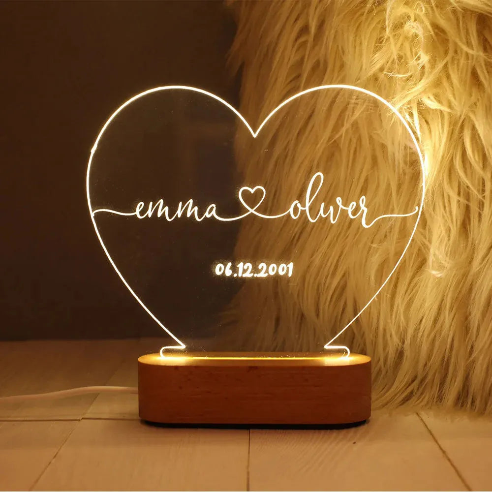 Custom acrylic night light with engraved names and date, lit by LED base.