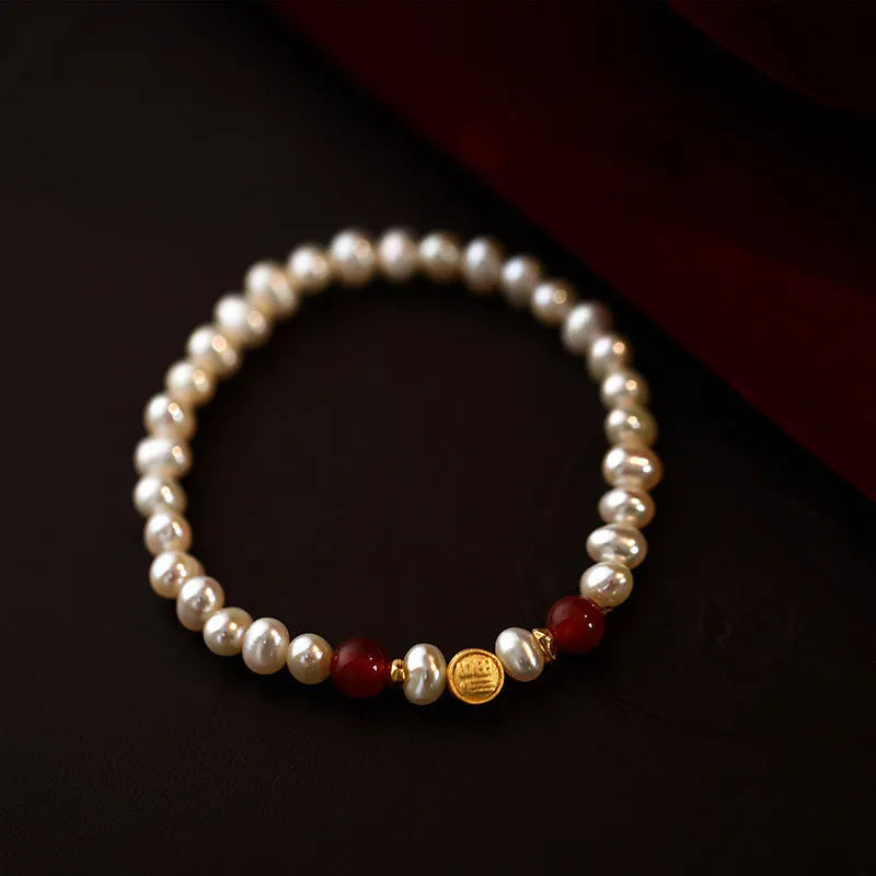 Natural freshwater pearl bracelet with Fu character charm on white background, silver chain, women's accessory