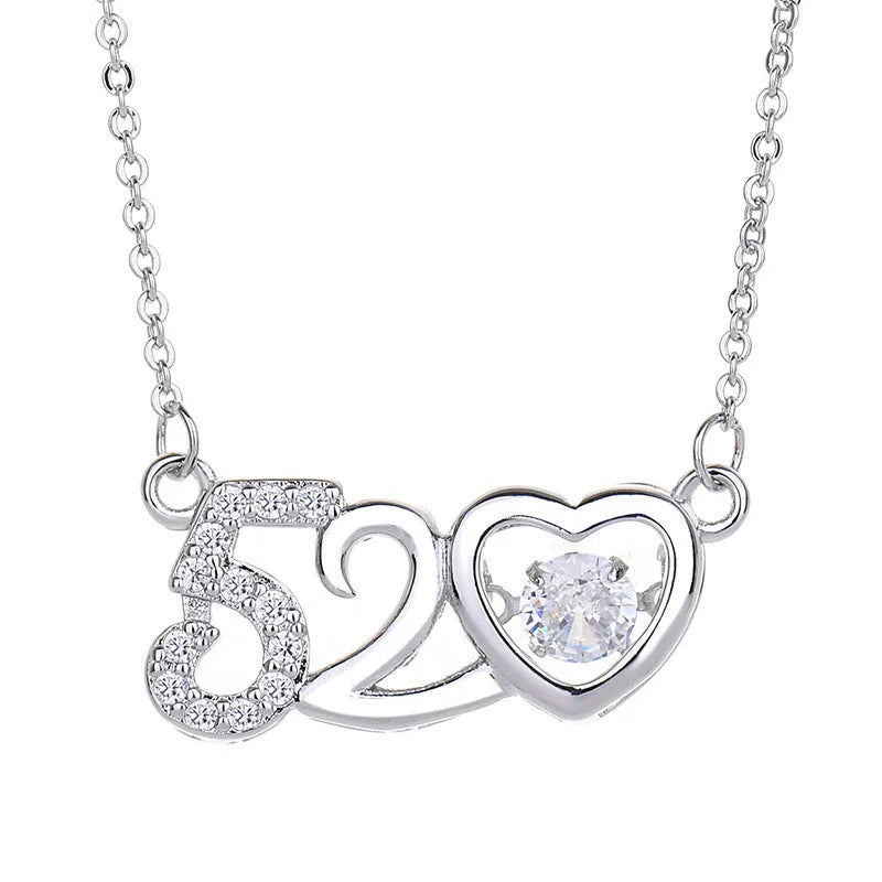 Silver tone heart pendant necklace with crown charm and bow detail on a delicate chain.