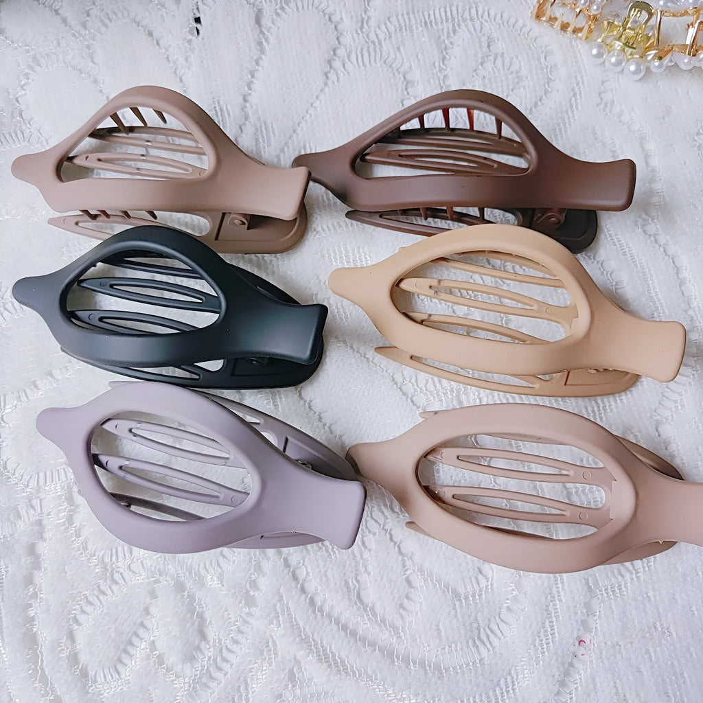 Six plastic hair clips with frosted grip texture and quadrilateral design in individual OPP bags