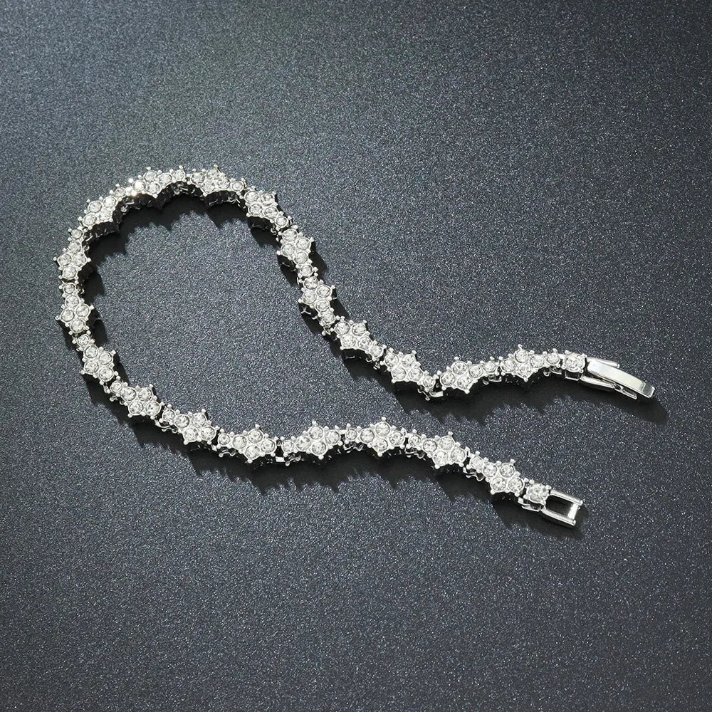 Flower-shaped cross tennis chain bracelet in gold alloy with diamond geometry pattern close-up