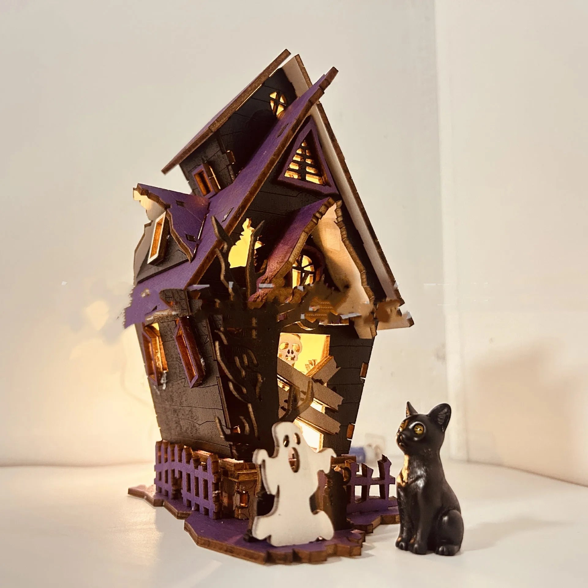 DIY wooden glowing haunted house Halloween table decoration and candlestick holder.