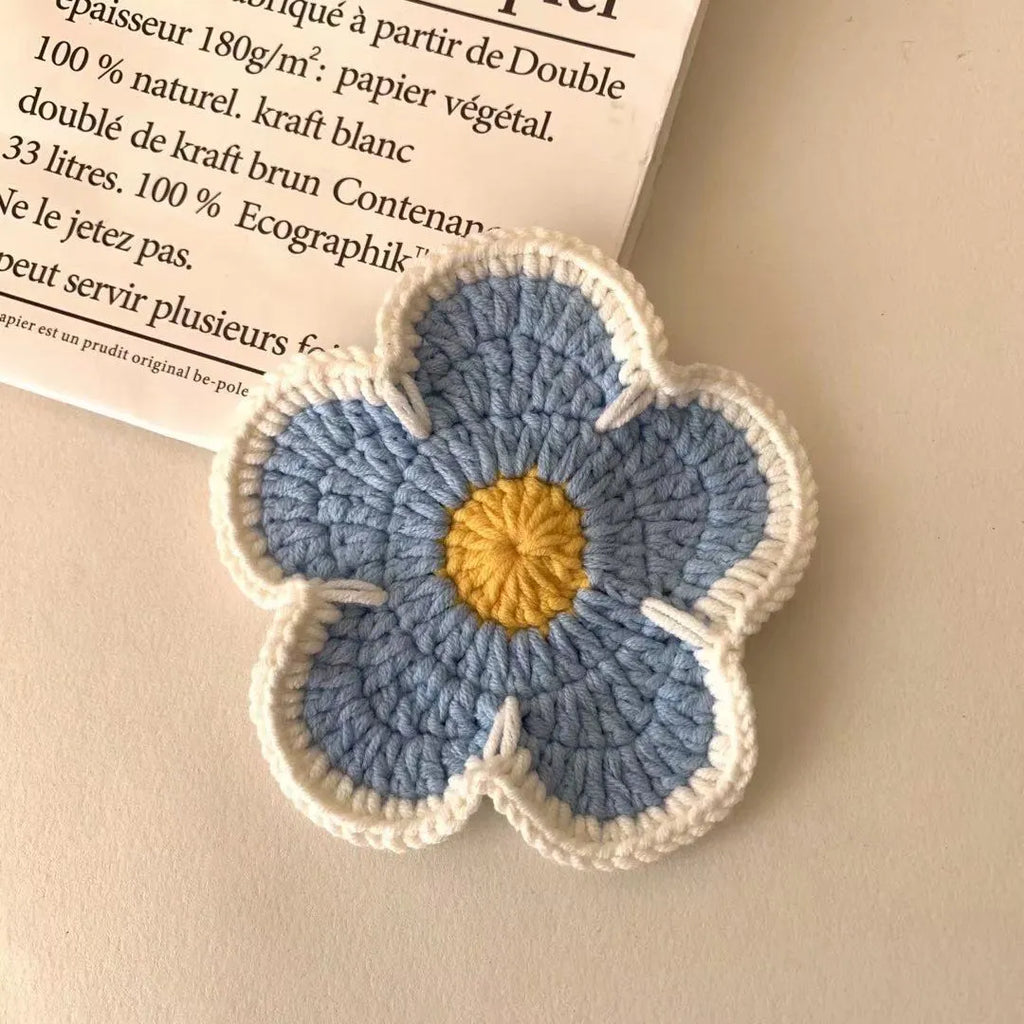 Set of five handmade woven cotton thread flower placemats in blue, green, orange, pink, and purple.