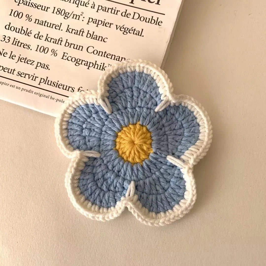 Set of five handmade woven cotton thread flower placemats in blue, green, orange, pink, and purple.