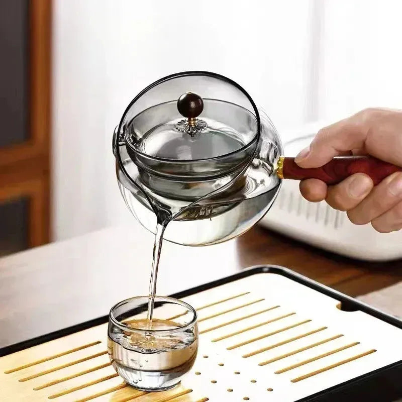 Transparent rotating glass teapot with wooden handle and integrated tea infuser