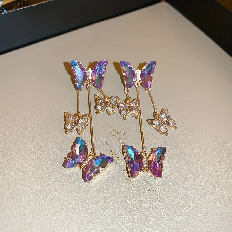 A pair of blue purple butterfly tassel earrings with silver needle crystal flowers on alloy posts.