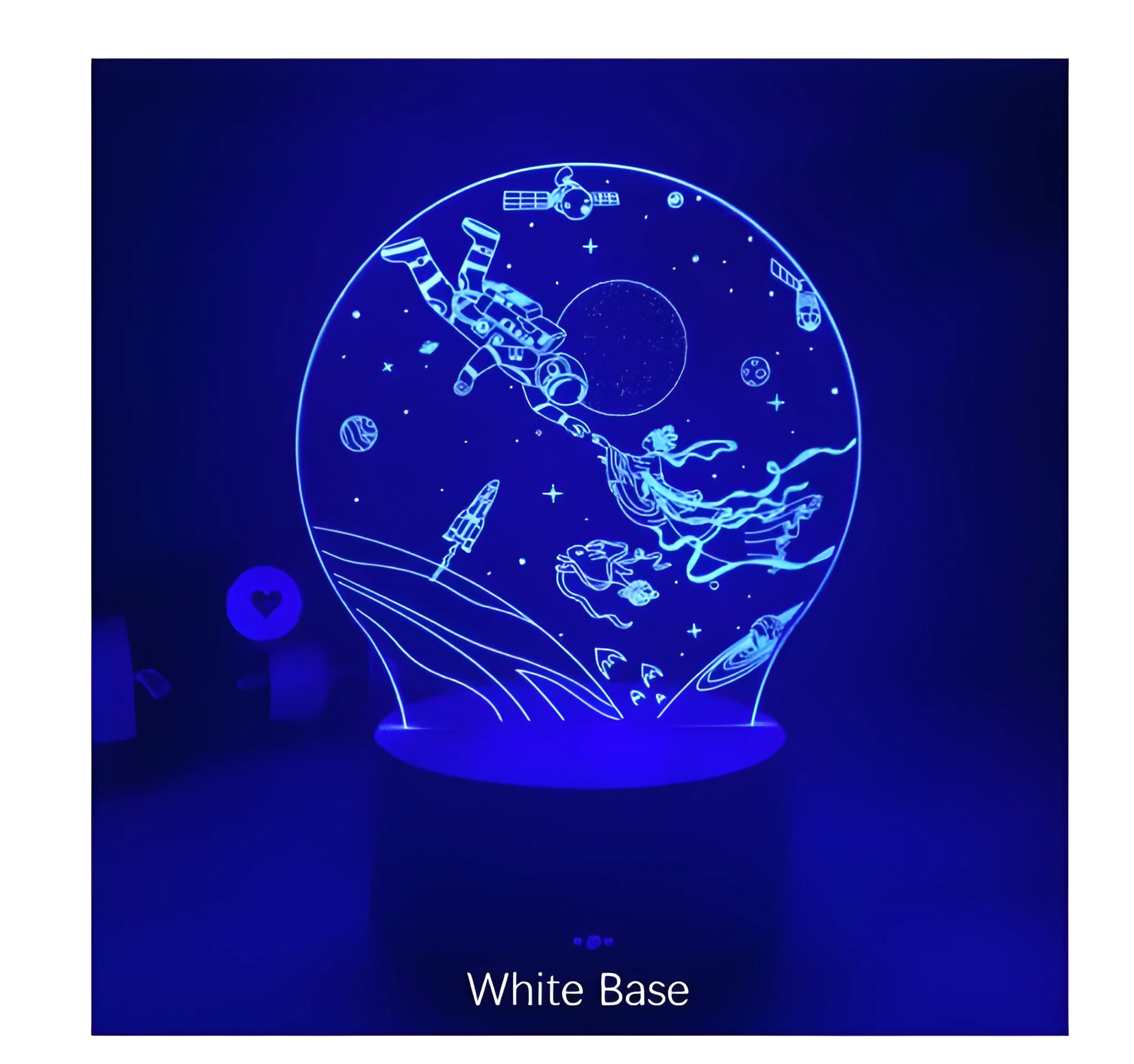 Colourful 3D night light in black base with remote control showing green glow on dark surface