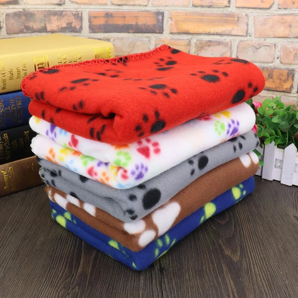 Pet warm blanket with paw print design double-sided fleece in blue colour, laid flat on a surface