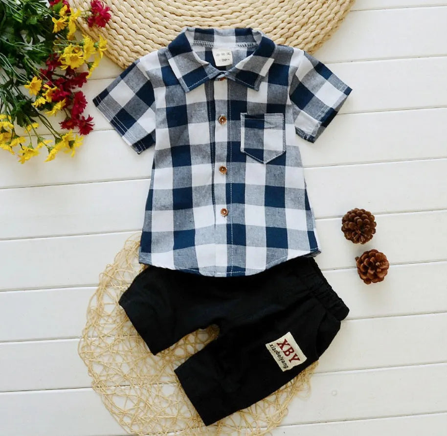 Baby boy wearing a blue crocodile print cotton t-shirt and matching blue shorts summer outfit set.