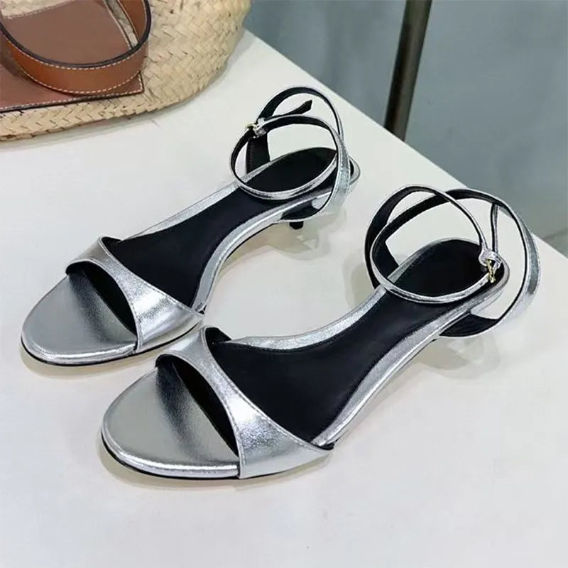 Women's black leather open toe sandals with a kitten heel and buckle fastening, retro Roman style.