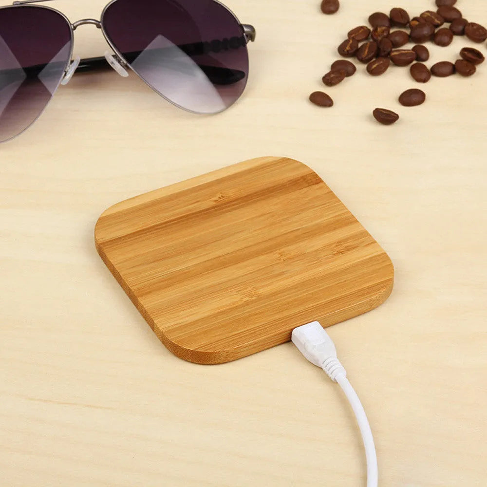 Square bamboo wood 5W wireless charger on a wooden surface.