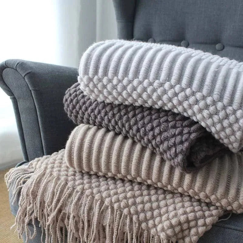 Small polyester fibre throw blanket in dark grey, shown folded, dimensions 127cm by 170cm.