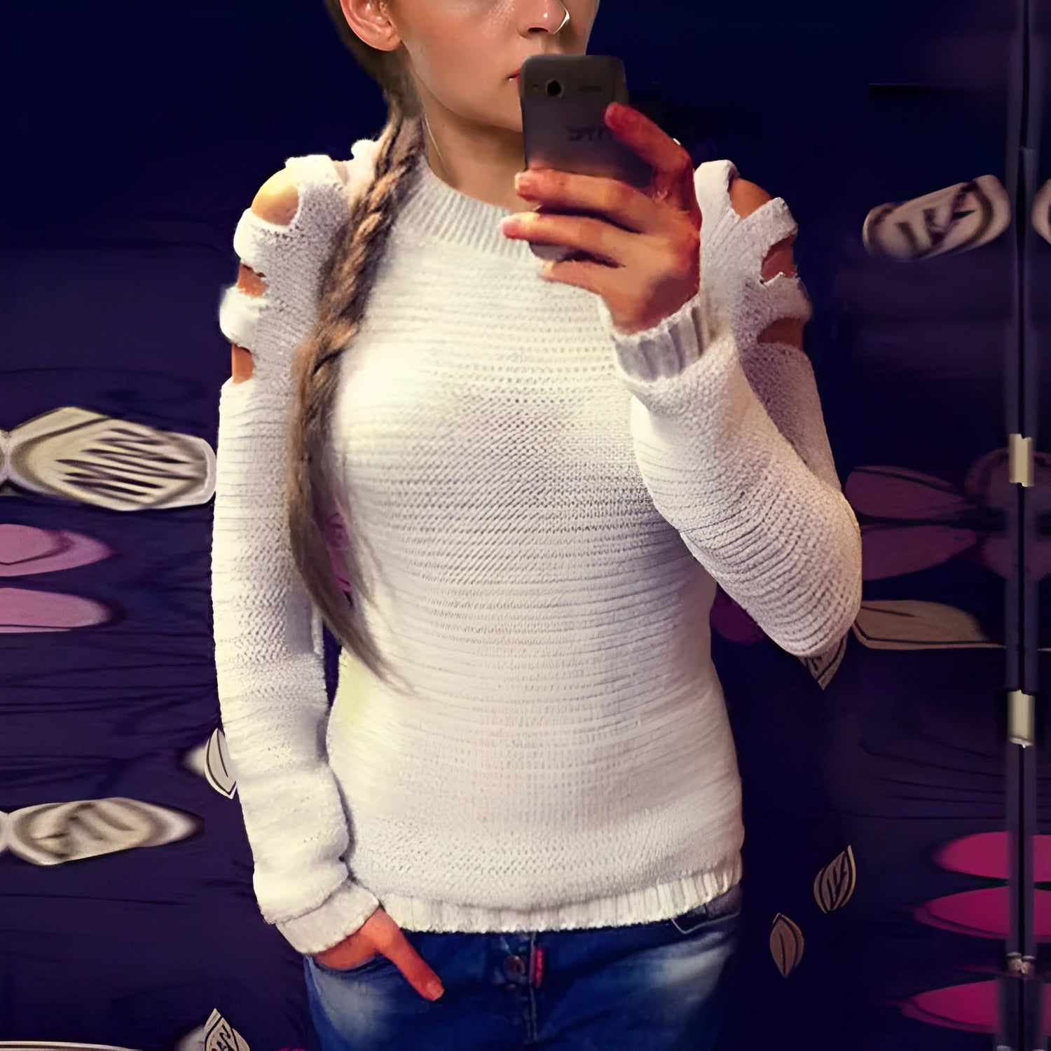 White women's hollow-out knitted long sleeve shirt with round neck on a hanger.