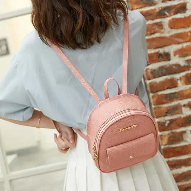 Compact black PU leather women's small backpack with a slim profile and zipper closure.