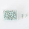 50 Morandi colour push pins with five-pointed star heads on a cork board