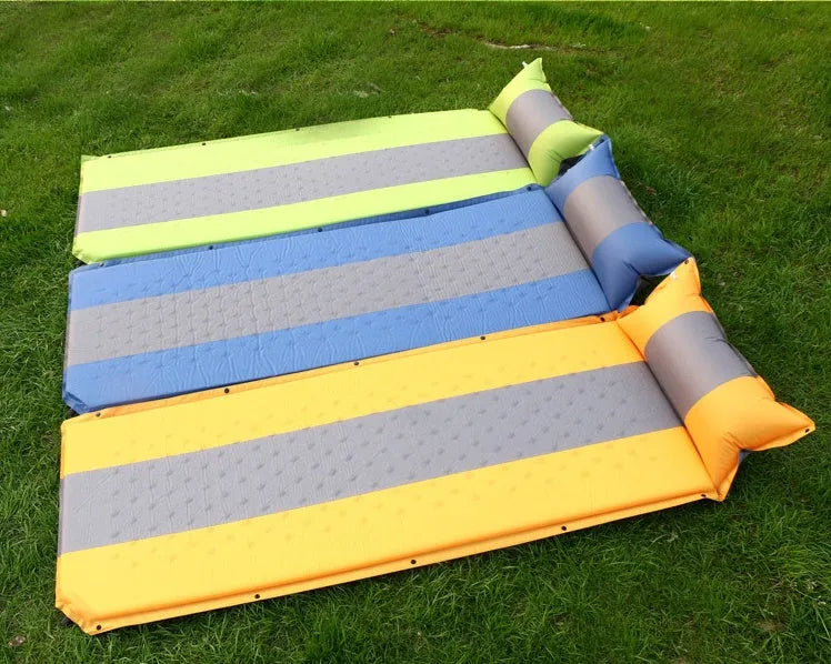 Outdoor automatic inflatable camping mat for one person with memory foam filling, blue and grey colour, shown on grass