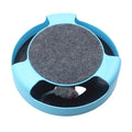 Blue rotating plastic cat toy with felt scratchpad on top standing on a floor