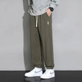 Men's loose grey cotton polyester sports trousers with elastic drawstring waist, laid flat.