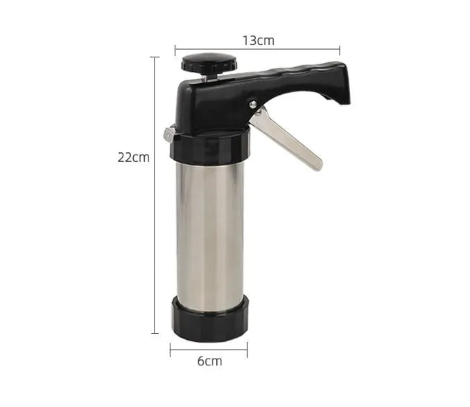 Stainless steel biscuit press machine with assortment of cookie moulds and piping nozzles on a kitchen worktop