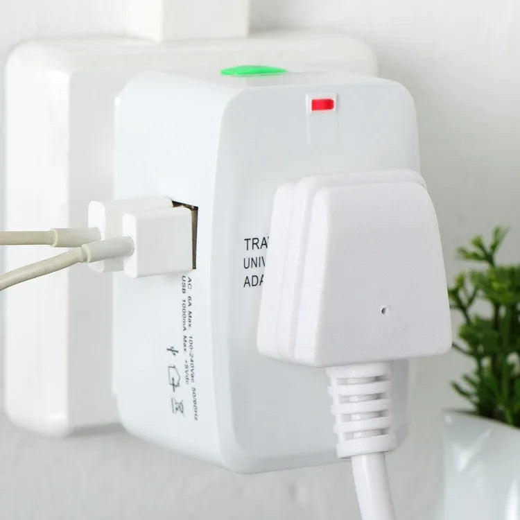 White universal travel plug adapter with dual USB ports and interchangeable UK EU US AU plugs on a plain background