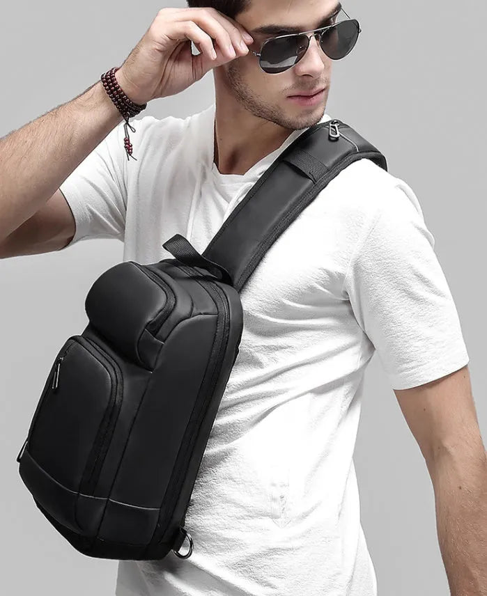 Black PVC outdoor leisure shoulder bag with a single strap, showing dedicated pockets for ID, phone, and computer.