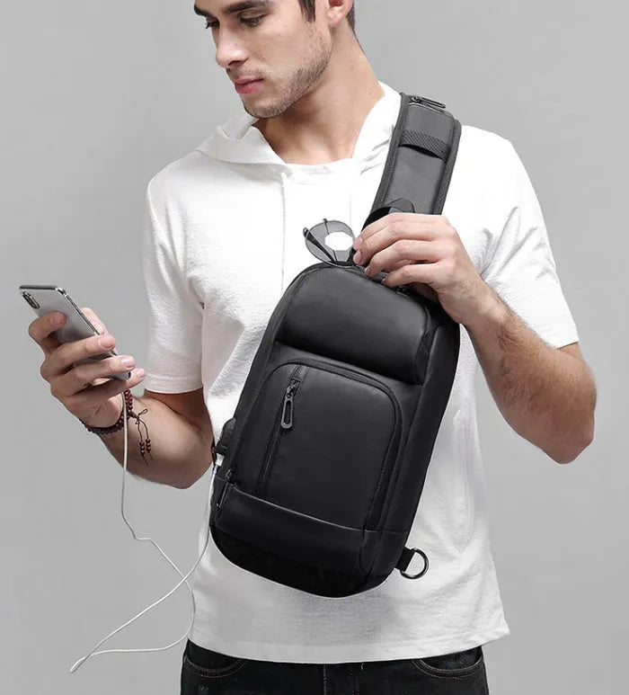 Black PVC outdoor leisure shoulder bag with a single strap, showing dedicated pockets for ID, phone, and computer.
