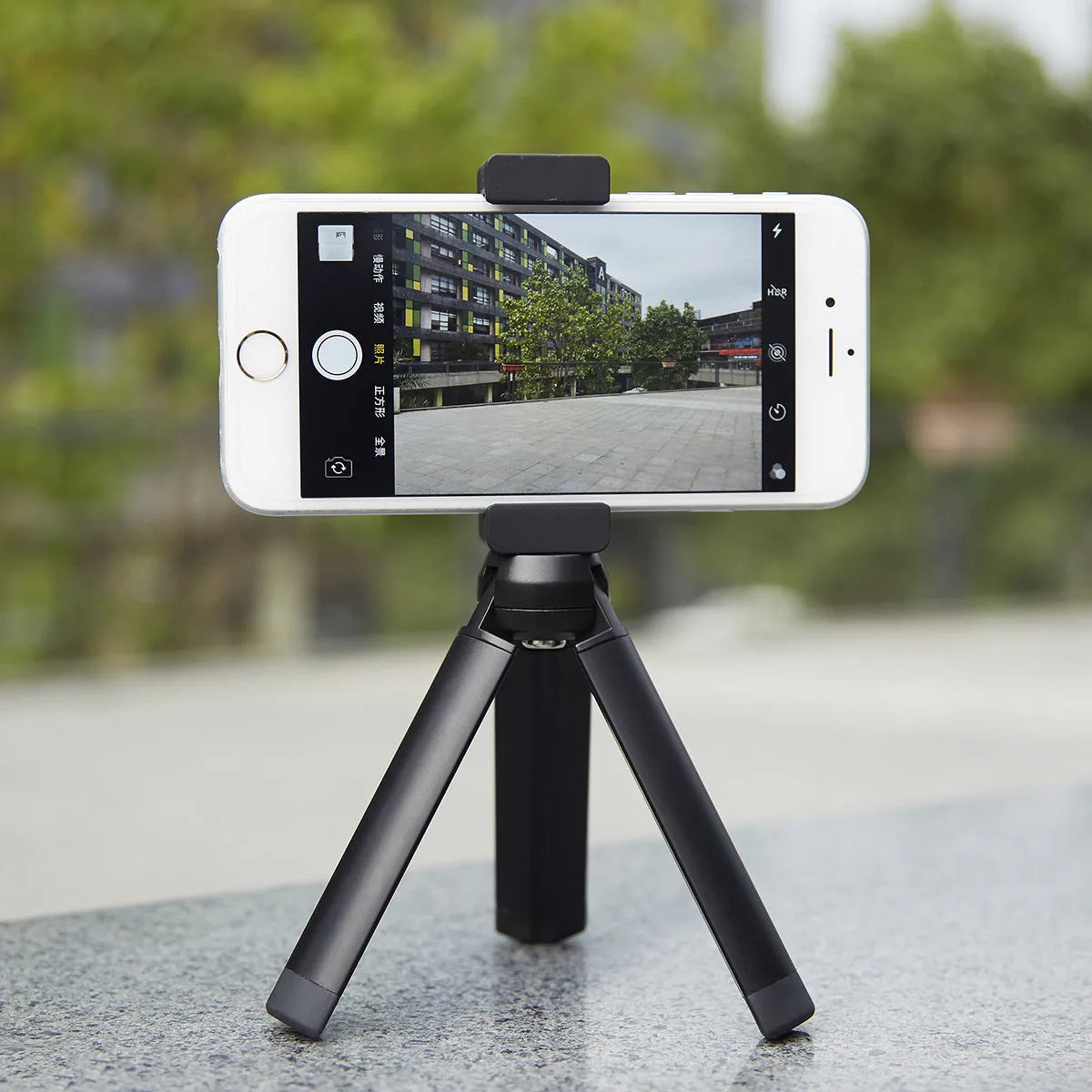Silver aluminium alloy clip bracket for mounting an Apple iPhone onto a table-top tripod.