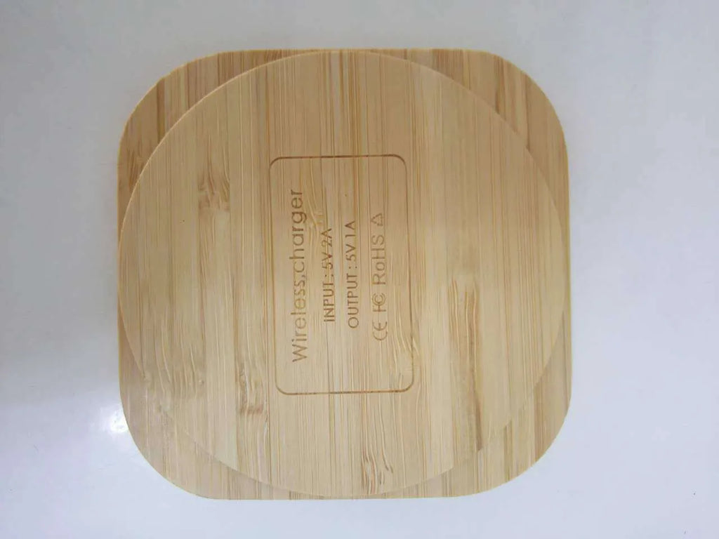 Square bamboo wood 5W wireless charger on a wooden surface.