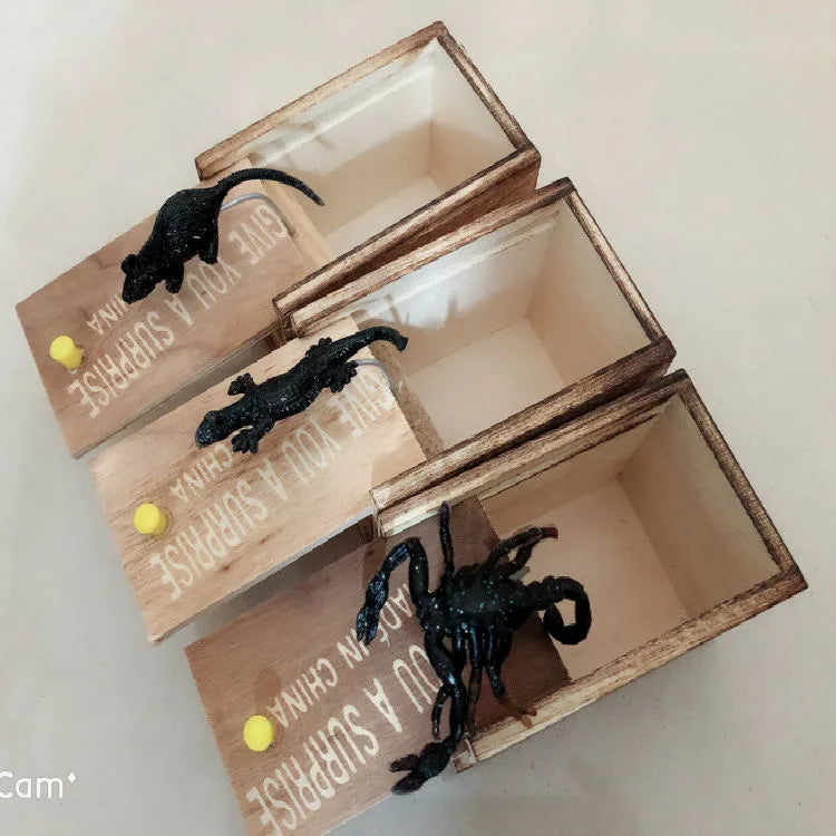 A closed wooden prank scare box measuring 9.1 cm, with a random lifelike animal inside ready to jump out.