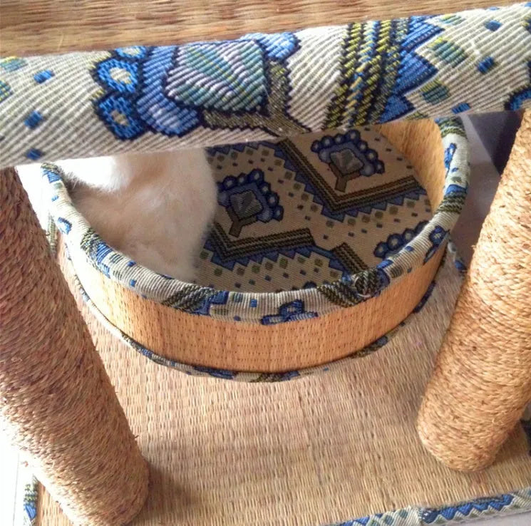 Cat playing on a natural wheat straw scratch board climbing frame with multiple levels