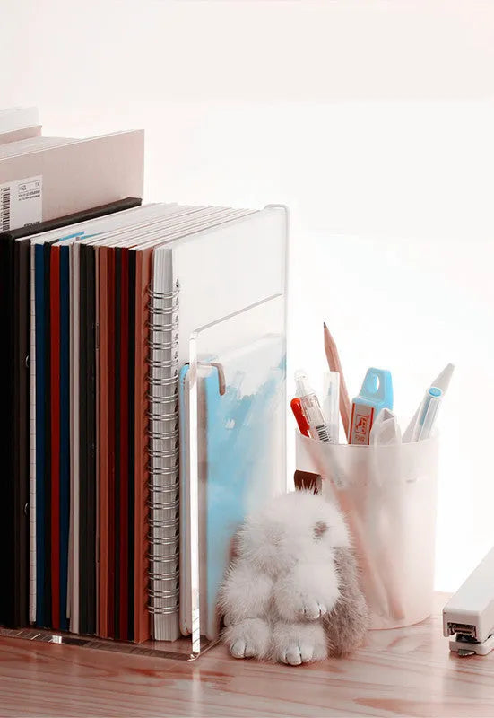 Transparent acrylic bookshelf displaying two books on a desk
