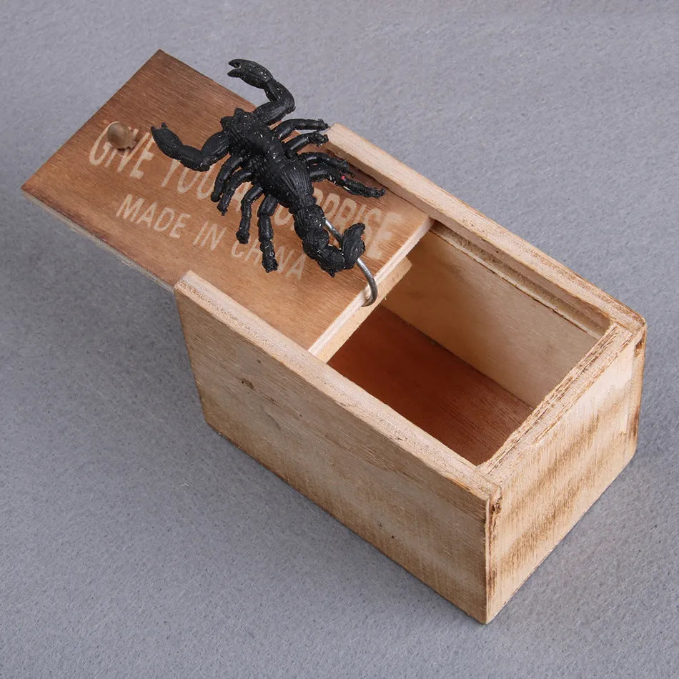 A closed wooden prank scare box measuring 9.1 cm, with a random lifelike animal inside ready to jump out.