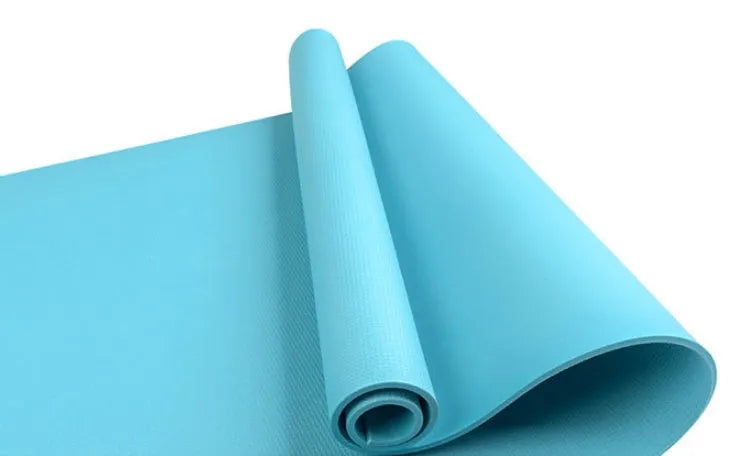 Red EVA fitness yoga mat rolled up next to its storage bag, showing textured surface.
