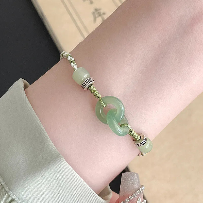 Green adjustable bracelet with jade peace buckle and copper zodiac charm.