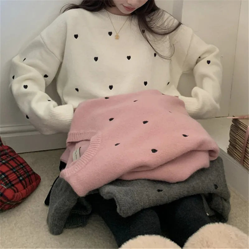 Women's loose cream embroidered acrylic pullover sweater with long sleeves, shown on a hanger.