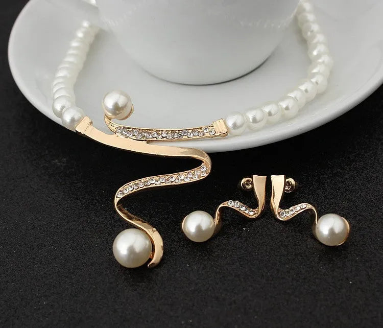 Gold electroplated pearl necklace and drop-shape earrings set on a jewellery display.