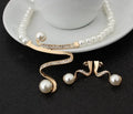 Gold electroplated pearl necklace and drop-shape earrings set on a jewellery display.