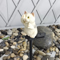Brown cat-shaped resin solar light standing in a garden