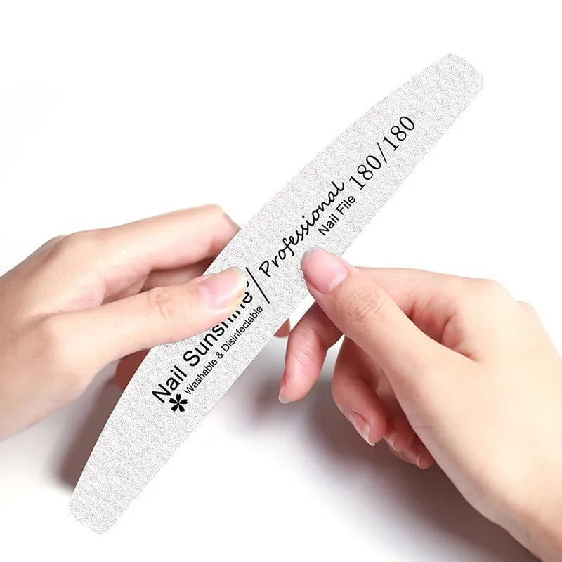 Grey half-moon shaped nail file with washable grit surface on a plain background.