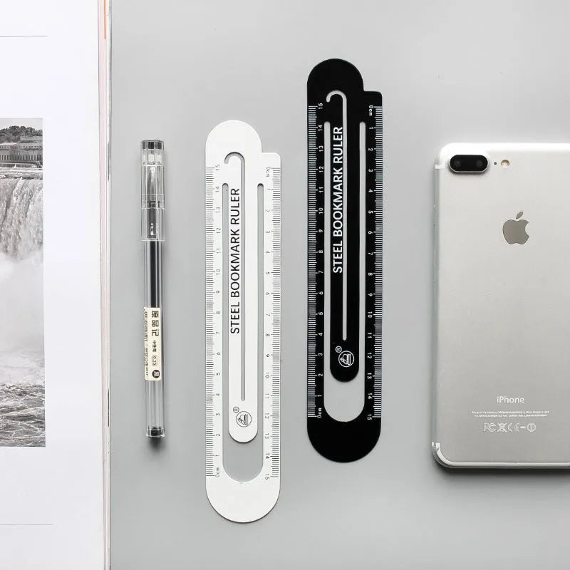 Black and white two-sided 12cm steel ruler on a wooden desk.